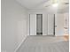 A bedroom with neutral carpet and walls, ceiling fan and closet at 206 Collegiate Cir, Durham, NC 27713