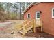 Exterior shot of back porch of a red brick home with wooded backyard at 2116 Nc Highway 751, Apex, NC 27523