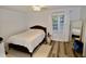 Bright bedroom with wood-look flooring, white walls, and natural light from the window at 2306 Stafford Ave # B, Raleigh, NC 27607