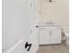A white half-bathroom featuring neutral floors and modern hardware at 2410 Carpenter Pond Rd, Raleigh, NC 27613
