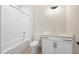 Bathroom featuring a shower and tub combination with white tile surround, plus a vanity sink with cabinets at 2410 Carpenter Pond Rd, Raleigh, NC 27613
