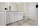 Bathroom featuring a double vanity sink with white cabinets, plus a toilet, shower, and decorative floor tiles at 2410 Carpenter Pond Rd, Raleigh, NC 27613
