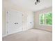 Bedroom featuring a closet and a large window with a forest view and neutral carpet and paint at 2410 Carpenter Pond Rd, Raleigh, NC 27613