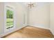 A light and airy room featuring hardwood floors, white trim, and large windows overlooking the yard at 2410 Carpenter Pond Rd, Raleigh, NC 27613