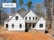 New construction home featuring a classic design, visible framing, and a landscaped front yard at 2410 Carpenter Pond Rd, Raleigh, NC 27613