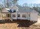 Two story home with a covered wooden porch is surrounded by bare trees at 2410 Carpenter Pond Rd, Raleigh, NC 27613