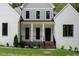 Charming home featuring white painted brick, a covered front porch, and black window trim at 2410 Carpenter Pond Rd, Raleigh, NC 27613