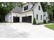 A bright white home featuring an attached garage with black garage doors and black window trim at 2410 Carpenter Pond Rd, Raleigh, NC 27613