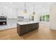 Spacious white kitchen with large island, modern appliances, and natural light at 2410 Carpenter Pond Rd, Raleigh, NC 27613