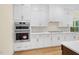 Gourmet kitchen boasts built-in stainless steel ovens and custom white cabinetry at 2410 Carpenter Pond Rd, Raleigh, NC 27613
