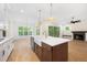 Spacious kitchen island with white countertops and farmhouse sink overlooks the living area at 2410 Carpenter Pond Rd, Raleigh, NC 27613