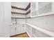 Walk-in pantry with open wooden shelves, quartz countertop, sink, and white cabinets at 2410 Carpenter Pond Rd, Raleigh, NC 27613