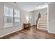 Bright living room showcasing hardwood floors, staircase, and large window allowing ample natural light at 2518 Magnolia Tree Ln, Durham, NC 27703