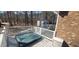 Backyard deck features hot tub, white railing, and wooded backdrop, perfect for relaxation at 266 Sagamore Dr, Louisburg, NC 27549