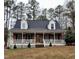 Inviting brick home with a spacious front porch, perfect for relaxing and enjoying the serene, wooded surroundings at 266 Sagamore Dr, Louisburg, NC 27549