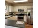 Kitchen features white cabinets, black countertops, and stainless steel appliances at 266 Sagamore Dr, Louisburg, NC 27549