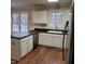 Kitchen features white cabinets, black countertops, stainless dishwasher and wood floor at 266 Sagamore Dr, Louisburg, NC 27549