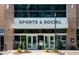Exterior of Sports & Social building with glass doors and large signage in a modern setting at 2906 Kempthorne Rd # 54, Cary, NC 27519