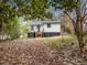 The backyard includes a deck attached to the house, complemented by mature trees and a mix of grass and leaves at 2908 Woods Pl, Raleigh, NC 27607