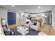 Open-concept living room and kitchen area with hardwood floors and stainless steel appliances at 2908 Woods Pl, Raleigh, NC 27607