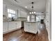 Modern kitchen with white cabinetry, granite countertops, an island, stainless steel appliances, and hardwood floors at 300 Nelson Ln, Clayton, NC 27527