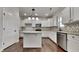 Modern kitchen with white cabinetry, granite countertops, an island, stainless steel appliances, and hardwood floors at 300 Nelson Ln, Clayton, NC 27527