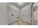 Well-lit laundry room with tile floors, storage shelf, and utility connections for modern appliances at 300 Nelson Ln, Clayton, NC 27527