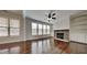 Bright living room featuring hardwood floors, large windows, a stone fireplace, and built-in shelving at 300 Nelson Ln, Clayton, NC 27527