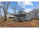 Charming one story home with a covered front porch and gray siding, surrounded by bare trees and a blue sky at 301 W Hill S Ave, Hillsborough, NC 27278