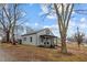 Quaint one-story home featuring gray siding, a covered porch and a large tree in the front yard at 301 W Hill S Ave, Hillsborough, NC 27278