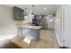 Bright kitchen with stainless steel appliances, gray cabinets, a breakfast bar, and stylish pendant lighting at 301 W Hill S Ave, Hillsborough, NC 27278