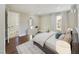 Bright main bedroom featuring wood floors, a large window, a dresser, and an ensuite entrance at 301 W Hill S Ave, Hillsborough, NC 27278