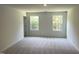 Neutral bedroom shows windows that provide views of a wooded area and neutral carpet at 3019 Vitner Dr, Durham, NC 27704