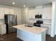 Bright kitchen boasts stainless steel appliances, a center island, and white cabinetry and countertops at 3019 Vitner Dr, Durham, NC 27704