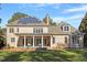 Brick house with a stone patio, pillars, a manicured lawn, and solar panels on a sunny day at 3605 Camp Mangum Wynd, Raleigh, NC 27612