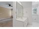 White bathroom showcasing a vanity with natural light, a ceiling fan, and carpet in the next room at 3605 Camp Mangum Wynd, Raleigh, NC 27612