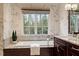Bathroom showcasing a tub under a window, floral wallpaper, and granite countertops at 3605 Camp Mangum Wynd, Raleigh, NC 27612