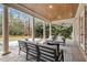 Elegant covered patio featuring brick accents, ceiling fans, comfortable seating, and a view of the well-maintained yard at 3605 Camp Mangum Wynd, Raleigh, NC 27612