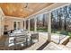 Relaxing covered patio with columns, ceiling fans, lounge furniture, and a view of the lush backyard and pool at 3605 Camp Mangum Wynd, Raleigh, NC 27612