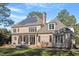 Brick two-story home featuring solar panels, a stone patio, and a covered back porch with white columns at 3605 Camp Mangum Wynd, Raleigh, NC 27612