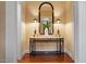 Elegant foyer featuring hardwood floors, decorative table with lamps, and a sophisticated mirror at 3605 Camp Mangum Wynd, Raleigh, NC 27612