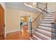 Elegant foyer with wooden staircase, hardwood floors, and view of a living area with natural light at 3605 Camp Mangum Wynd, Raleigh, NC 27612