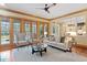 A sunlit living room with hardwood floors and views to the back patio and kitchen at 3605 Camp Mangum Wynd, Raleigh, NC 27612