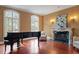Living room features hardwood floors, a fireplace, and a piano with lots of natural light through large windows at 3605 Camp Mangum Wynd, Raleigh, NC 27612