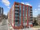 Modern red brick building with large windows and balconies against a blue sky at 400 Hunt St # 404, Durham, NC 27701