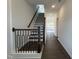 Hallway with dark hardwood floors, white walls, black railing, and a view of the staircase at 4301 Darius Lane # 28, Fuquay Varina, NC 27526