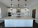 Bright kitchen with a large white island, modern pendant lighting, and sleek appliances at 4301 Darius Lane # 28, Fuquay Varina, NC 27526