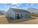 View of the home's rear exterior showing the patio, lawn, and the yard's HVAC system at 45 Florentine Ct, Angier, NC 27501