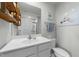 Well-lit bathroom featuring a white vanity, decorative shelving, and tasteful wall art at 45 Florentine Ct, Angier, NC 27501
