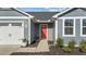A close-up of the home's entryway, highlighting the red front door and well-kept landscaping at 45 Florentine Ct, Angier, NC 27501